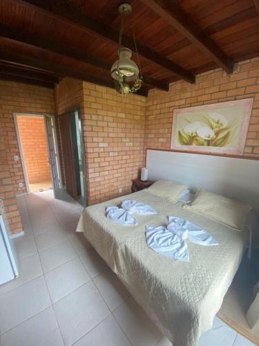 a bedroom with a bed in a brick wall at HervaDoce in Rio das Ostras