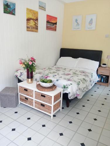 a bedroom with a bed and a table with flowers on it at Kaye Daisy in Vieux Fort
