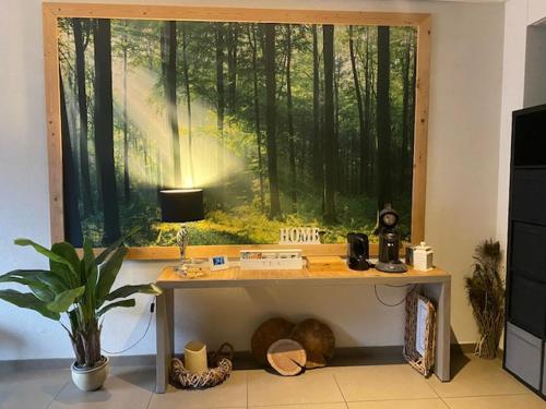 a room with a desk in front of a large window at Kom tot rust in The Forest in Putte