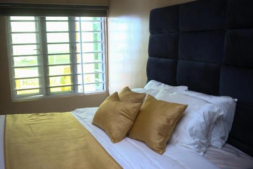 a bed with two pillows and a blue headboard at Isimi haven in Lekki