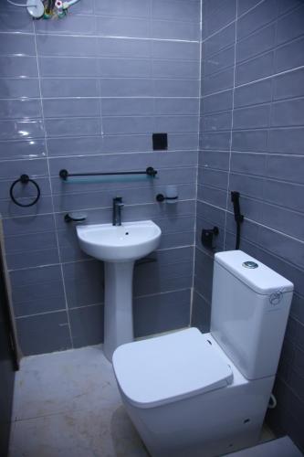 a bathroom with a white toilet and a sink at Isimi haven in Lekki