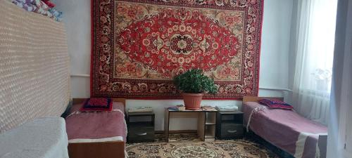 a room with two beds and a large rug at STALBEK Guest House in Kochkorka