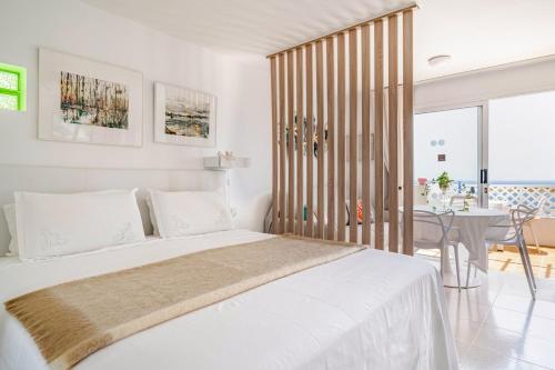 a white bedroom with a bed and a table at Vittorio Fabulous View in Tías