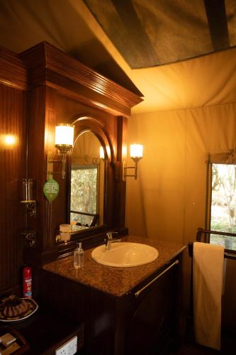 a bathroom with a sink and a mirror at Kirawira Serena Camp in Handajega