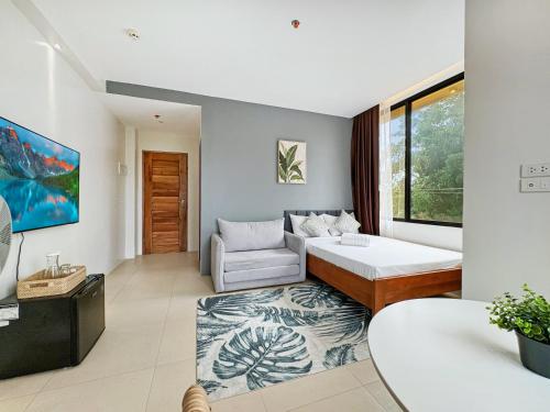 a living room with a bed and a couch at El Jardin Residences in Panglao Island