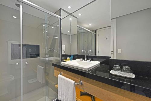 a bathroom with a sink and a shower at Hotel Deville Prime Salvador in Salvador