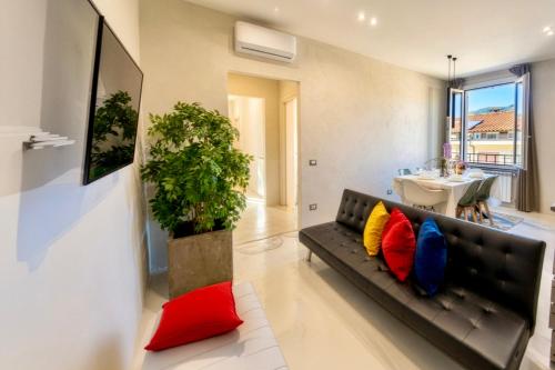 a living room with a black couch with colorful pillows at Signature Design & Panoramic Views in Montecatini Terme