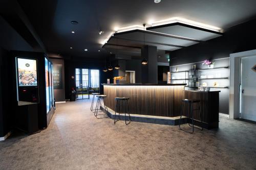 a restaurant with a bar and stools in a room at JustStay Mülheim Oberhausen Hotel & Apartments in Mülheim an der Ruhr