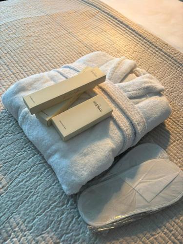 a towel and a phone sitting on top of a bed at Hotel Sweet Night in Kazbegi