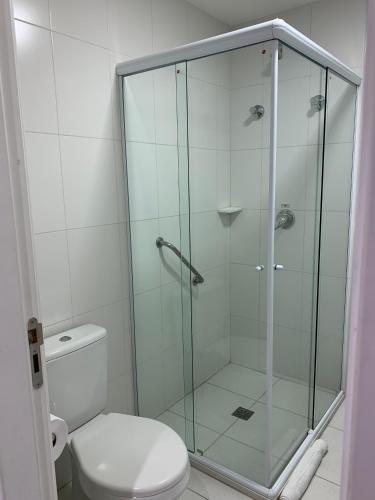 a glass shower in a bathroom with a toilet at Summit Beach Hotel Boiçucanga in Boicucanga
