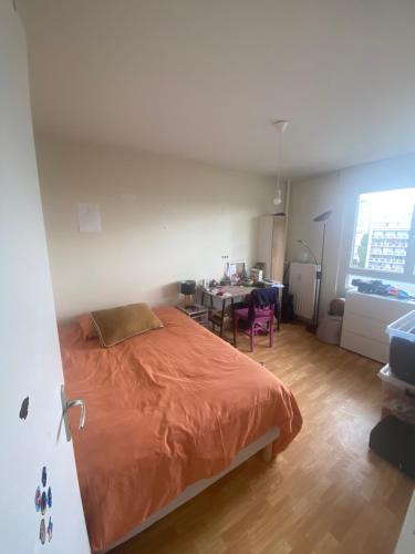 a bedroom with a bed and a table in a room at Appartement Antoine in Rennes