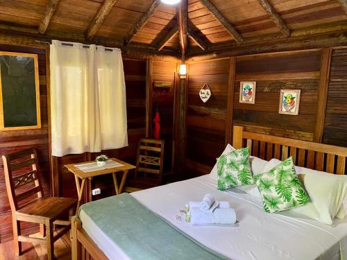 a bedroom with a bed with towels on it at Pousada Recanto Afetivo in Trindade