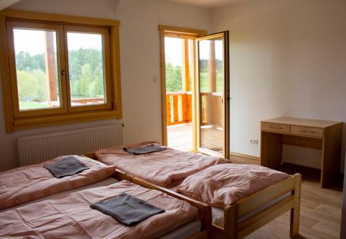 two beds in a room with a window at Usedlost u rybníka in Velký Bor