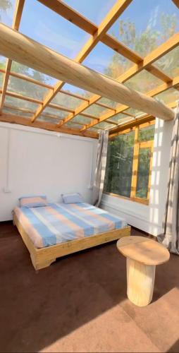 a bedroom with a bed and a table and a window at Nivriti Stays in Nainital