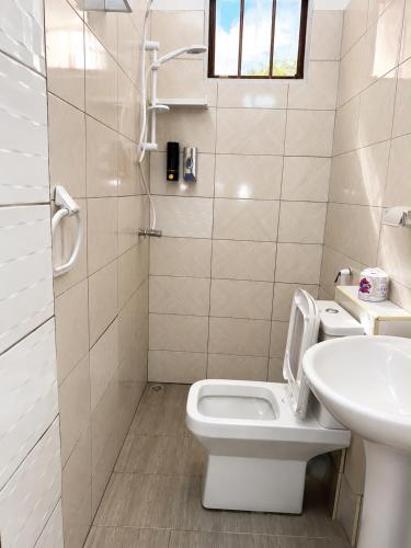 a white bathroom with a toilet and a sink at Lamu Creek Hotel in Lamu