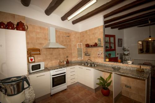 a kitchen with a sink and a stove top oven at Cal Manyo in Puigvert de Lérida