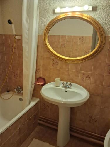 a bathroom with a sink and a mirror and a tub at Hameau des Granges in Bourisp