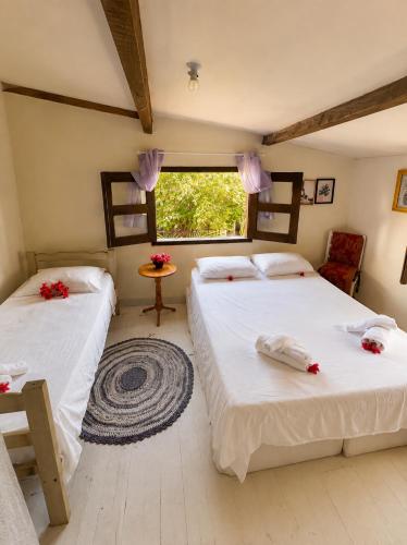 a bedroom with two beds and a window at Residencial dos Freitas in Jericoacoara