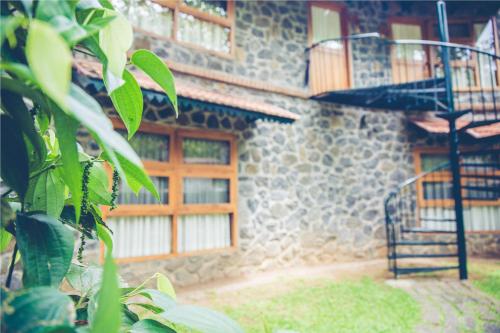 a stone building with a spiral staircase in front of it at Wildernest in Thekkady