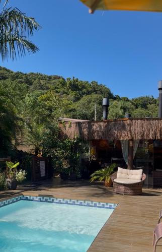 a resort with a swimming pool and a patio at Pousada Rosa Astral ॐ in Praia do Rosa