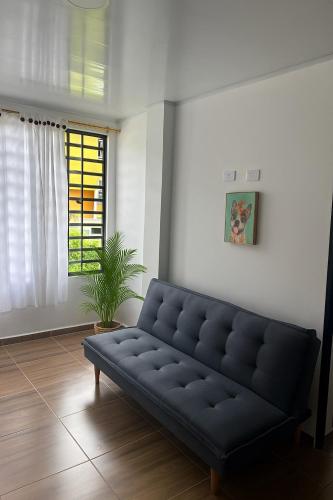 a black couch in a living room with a window at Apartamentos El Remanso in Mariquita