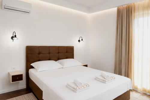 a bedroom with a white bed with two towels on it at Villa Blanco in Mostar