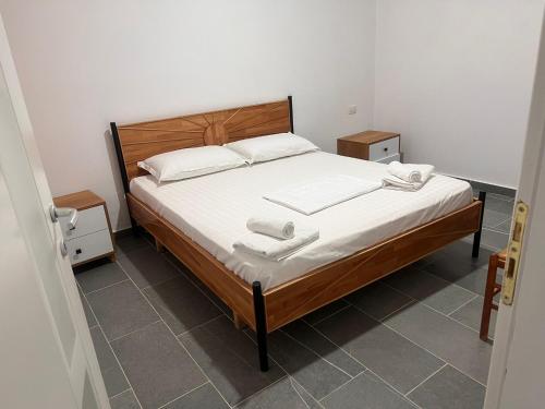 a bedroom with a bed with two towels on it at Vila Rei in Borsh