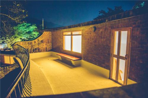 a balcony with a bench on a brick building at Wildernest in Thekkady