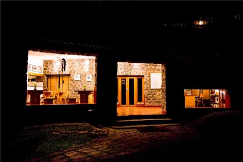 an open door of a stone house at night at Wildernest in Thekkady
