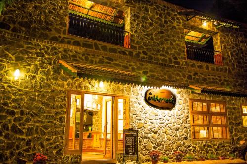 a stone building with a door and a sign on it at Wildernest in Thekkady