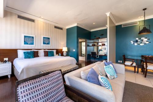 a bedroom with a bed and a couch and a living room at Hotel Deville Prime Salvador in Salvador