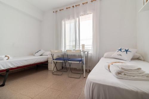 a room with two beds and a table and chairs at Apt Italia 96 in Almarda