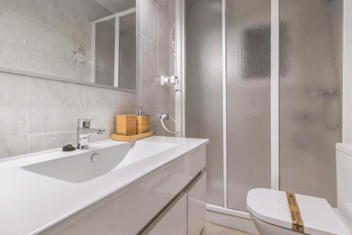 a white bathroom with a sink and a shower at Apt Italia 96 in Almarda