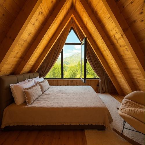 a bed in a room with a large window at Monte Casa Žabljak in Žabljak