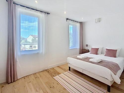 a white bedroom with a bed and a window at Evasions-Dérobade, centre-ville, gare in Auterive