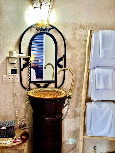 a bathroom sink with a mirror in a room at Yes We Camp Agafay Luxury Khaïma & Restaurant - Spa in El Karia