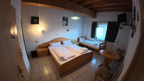 a bedroom with a bed and a room with a table at Landhotel Eifelblick in Stadtkyll