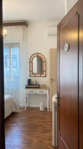 a room with a bed and a table and a mirror at Minerva in Viareggio