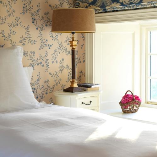 a bed with a lamp on a night stand next to a window at Tankardstown House in Slane