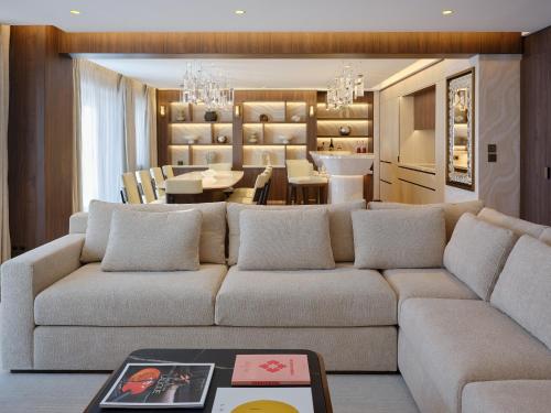 a living room with a couch and a dining room at Maya Hôtel Courchevel 1850 in Courchevel
