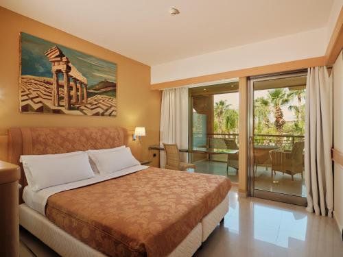 a hotel room with a bed and a balcony at Acacia Resort in Campofelice di Roccella