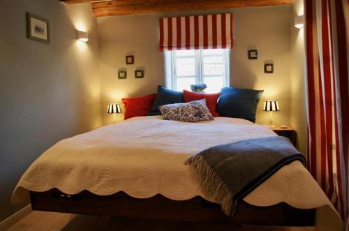 una camera da letto con un letto grande con cuscini rossi e blu di Ferienhaus nahe Ostsee mit Sauna, Kamin & eingezäuntem Garten,Hund willkommen a Rabenholz