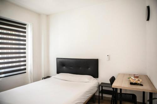 a bedroom with a bed and a table and a window at Next Stop Atocha in Madrid
