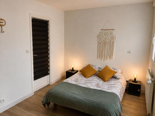 a bedroom with a bed with yellow pillows and a chandelier at l 'Escapade Atlantique in Saint-Nazaire