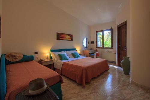a bedroom with two beds and a window at Hotel Village Eden in Capo Vaticano