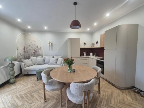 a kitchen and living room with a table and a couch at Apartamenty u Justyny - Ametyst in Borne Sulinowo