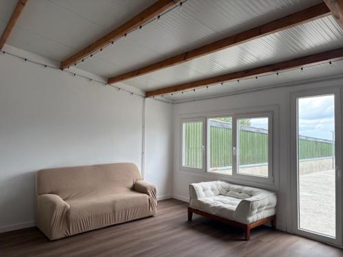 a living room with a couch and a chair and a window at Lar de Luz in Palas de Rei