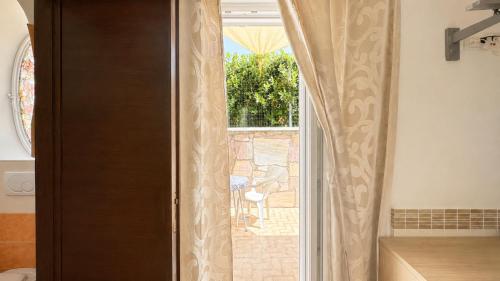 a sliding glass door to a patio with a window at Hotel Aragonese Ischia in Ischia Town