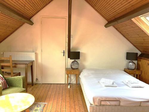 a bedroom with a bed and a table and a chair at Phare - SAINT HILAIRE DE RIEZ in Saint-Hilaire-de-Riez