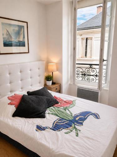 a bedroom with a white bed and a window at appartement centre ville in Souillac